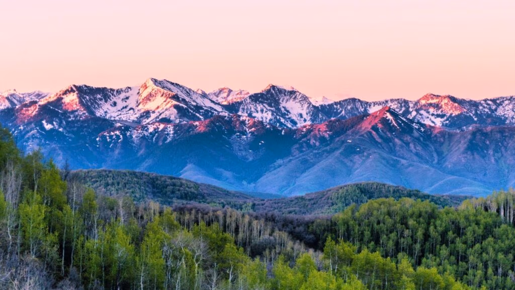 Snow-capped mountains at sunrise over Wasatch County, Utah, showcasing natural beauty and community landscape.