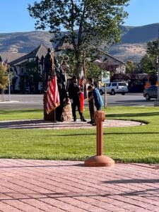 Community members engaging with a memorial statue surrounded by American flags in Wasatch County, emphasizing local law enforcement and community trust.