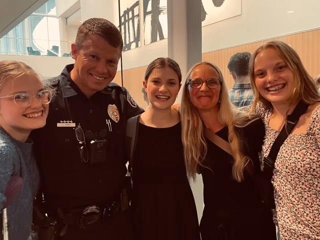 Smiling police officer with four young women, promoting community safety and engagement in Wasatch County.